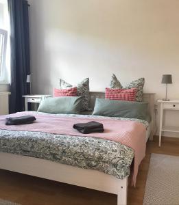 a bedroom with a large bed with red and green pillows at Ferienwohnung am Wald in Sebnitz