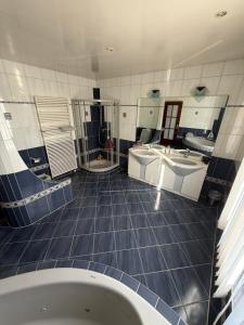 a large bathroom with two sinks and a tub at La maison du petit bonheur in Moutier