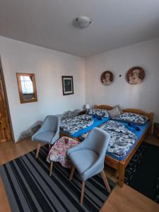 a bedroom with three beds and two chairs at Penzión Evka in Poprad