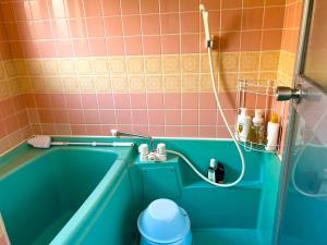 a bathroom with a blue tub and pink tiles at 媛楽園Himerakuen in Matsuyama +29 photos
