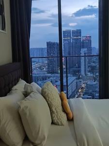 a bed with pillows and a view of a city at Continew Residence by TM House in Kuala Lumpur +35 photos