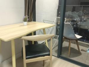 a wooden table and a chair next to a window at Continew Residence by TM House in Kuala Lumpur
