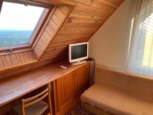 a room with a desk with a tv and a window at Podkamiencem in Odrzykoń