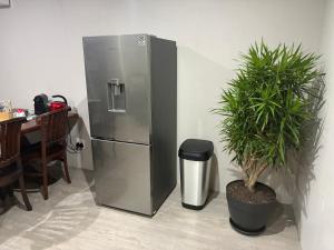 a stainless steel refrigerator with a potted plant next to a table at Swanepoel Guesthouse in Jeffreys Bay +83 photos