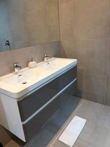 a bathroom with a white sink and a mirror at Swanepoel Guesthouse in Jeffreys Bay