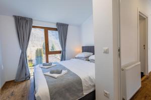 a bedroom with a large bed and a window at Nessa Chalet in Moara de Pădure