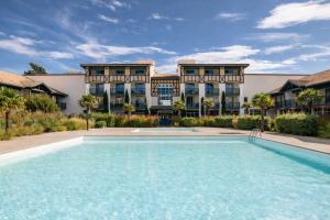 a swimming pool in front of a building at Maison villa Lilou, Pierre et vacances, avec piscine, vue sur le golf, plage à 10 min à pied in Moliets-et-Maa
