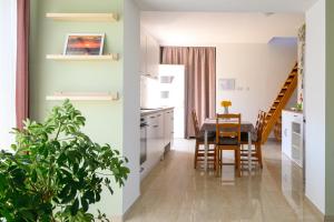 a kitchen and a dining room with a table at Majoros Garden Apartman in Siófok +17 photos