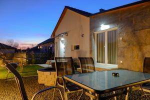 a glass table and chairs on a patio at Majoros Garden Apartman in Siófok