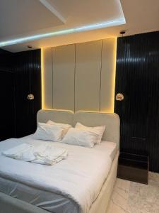 a bed with white sheets and pillows in a room at TheEliteHavenshortlet in Lekki