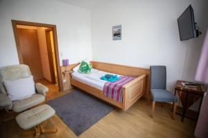 a small bedroom with a bed and a chair at Frühstückspension Josefinum in Bad Aussee