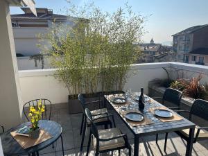 a patio with two tables and chairs on a balcony at Attico Don Minzoni in Intra