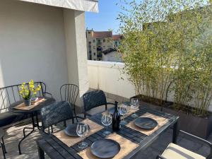 a table and chairs on a balcony with a table and glasses at Attico Don Minzoni in Intra