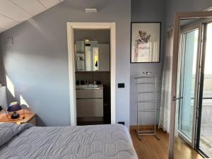 a bedroom with a bed and a bathroom with a sink at Attico Don Minzoni in Intra