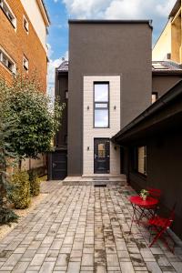 a house with a brick courtyard with a black door at ARI Central Location in Arad