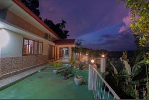 a house with a balcony at night at Emerald Hill Bungalow in Kandy