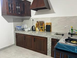 a kitchen with wooden cabinets and a counter top at Emerald Hill Bungalow in Kandy