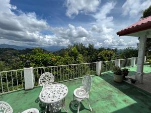 a balcony with chairs and a view of the mountains at Emerald Hill Bungalow in Kandy