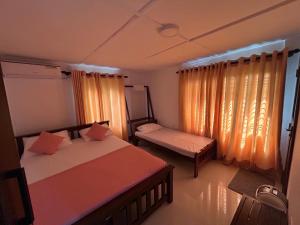 a bedroom with two beds and a window at Emerald Hill Bungalow in Kandy