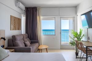 a living room with a bed and a couch and a table at Apartamentos Mirador in Benidorm
