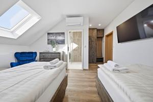 two twin beds in a room with a tv at Blatenský dvůr in Pardubice
