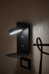 eine Lampe an einer Wand mit einer Lampe darauf in der Unterkunft Da Cuful in Reana del Roiale