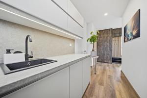 a kitchen with white cabinets and a sink at Blatenský dvůr in Pardubice