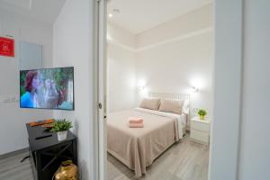 a bedroom with a bed and a tv on a wall at Mimi's Apartment in En Corts in Valencia