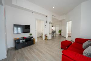 a living room with a red couch and a tv at Mimi's Apartment in En Corts in Valencia