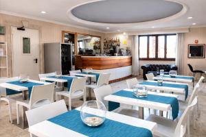 a restaurant with blue tables and white chairs at Hotel Riviera Fiumicino in Fiumicino
