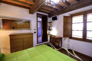 a bedroom with a green bed and wooden cabinets at La Locanda di Giulia in Arezzo