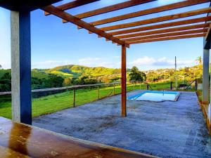 a pavilion with a pool and a view of the mountains at Casa Goulart in Capitólio