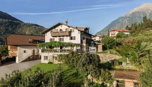 a house on a hill with mountains in the background at Baumgartnerhof in Lagundo