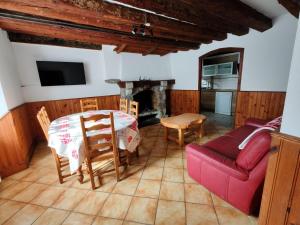 a living room with a table and a red couch at Les Nids Pyrénéens in Castillon-de-Larboust