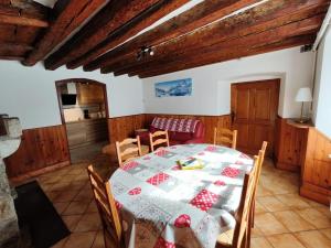 a dining room with a table and a couch at Les Nids Pyrénéens in Castillon-de-Larboust