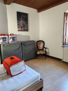a room with a bed and a chair in it at Les Nids Pyrénéens in Castillon-de-Larboust