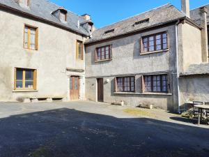 an old house with a driveway in front of it at Les Nids Pyrénéens in Castillon-de-Larboust
