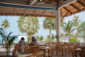 two people sitting at a restaurant with palm trees at The One Resort in Koh Rong Island