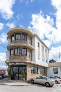 a building with a car parked in front of it at SNÖ Porta das Fragas in A Capela