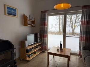 a living room with a television and a table and a window at Seeschwalbe in Munkbrarup