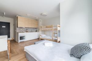 a small apartment with a bed and a kitchen at Luboń Urban Nest Studio by BookingHost in Luboń