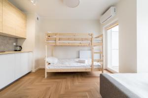 a bedroom with two bunk beds and a kitchen at Luboń Urban Nest Studio by BookingHost in Luboń