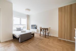 a bedroom with a bed and a table and a desk at Luboń Urban Nest Studio by BookingHost in Luboń