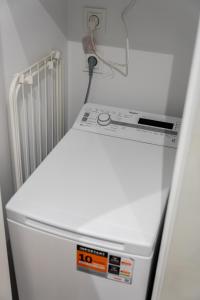 a white refrigerator in a room with a radiator at Luboń Urban Nest Studio by BookingHost in Luboń