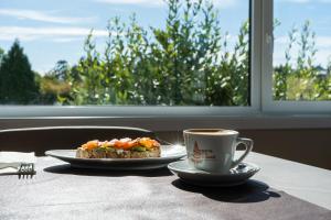 a plate of food and a cup of coffee on a table at SNÖ Porta das Fragas in A Capela