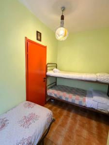 a room with two bunk beds and a red door at Trilocale Prealpi in Margno