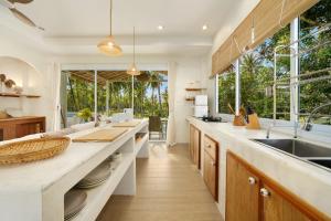a kitchen with a large counter and windows at Baan Boho Villas in Ko Phangan