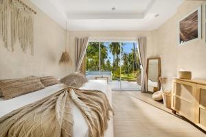 a bedroom with a bed with a large window at Baan Boho Villas in Ko Phangan +16 photos