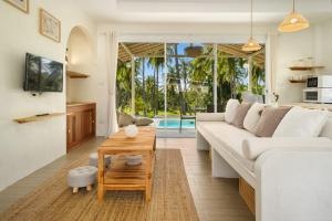 a living room with a white couch and a table at Baan Boho Villas in Ko Phangan