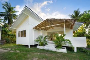 a white house with palm trees in front of it at Baan Boho Villas in Ko Phangan